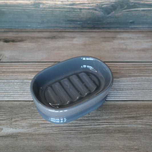 Shiny gray oval soap dish, empty, top view.