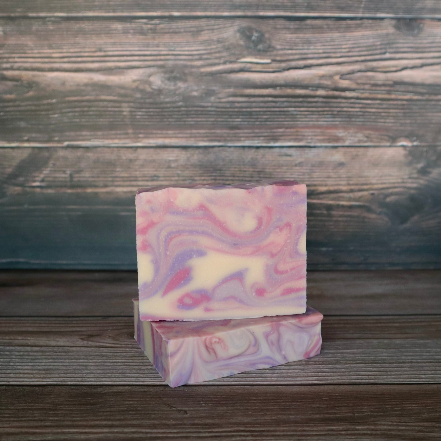 Two bars of soap colored pink, purple and white swirled together to represent berry colors.
