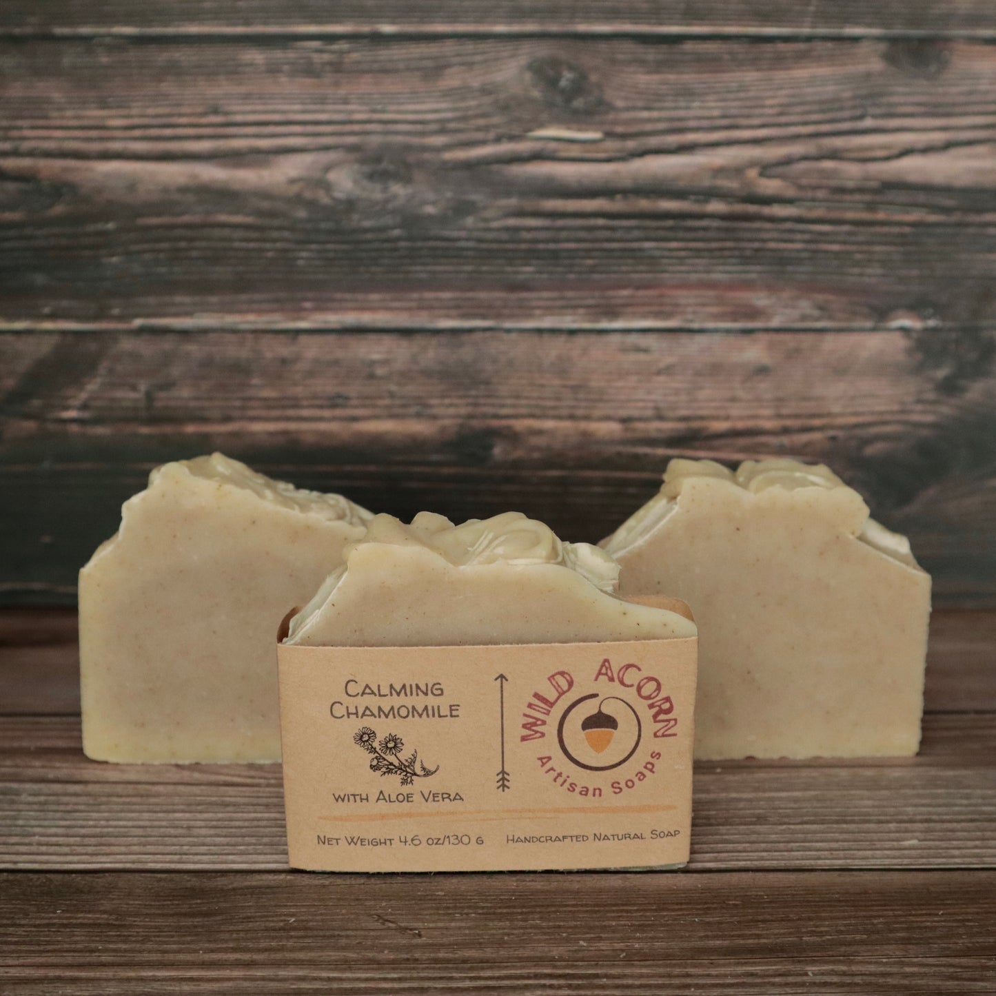 picture of a soap that is a light cream color with a high top and speckled with chamomile flakes