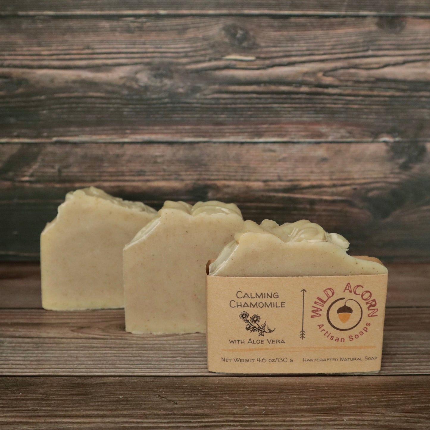 picture of a soap that is a light cream color with a high top and speckled with chamomile flakes