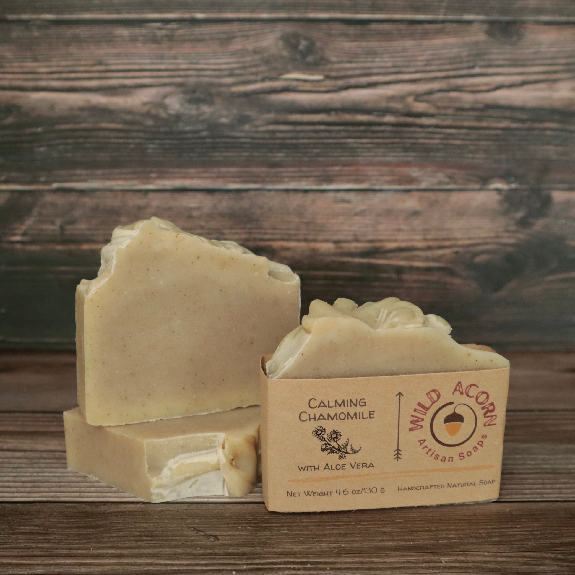 picture of a soap that is a light cream color with a high top and speckled with chamomile flakes