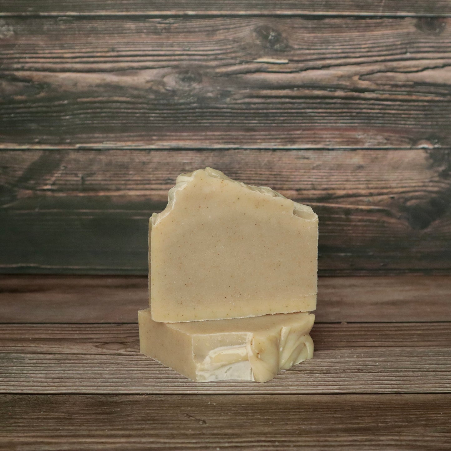 picture of a soap that is a light cream color with a high top and speckled with chamomile flakes