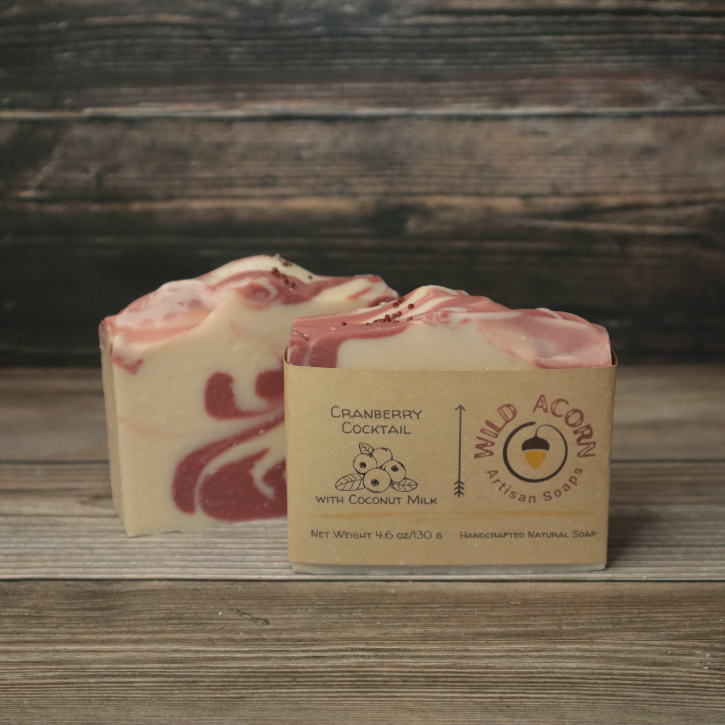 2 bars of soap, cream colored with red swirls and tiny red cranberry seeds on top.