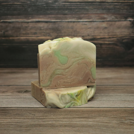 picture of soap with green, brown, and cream colored swirls with green glitter on top
