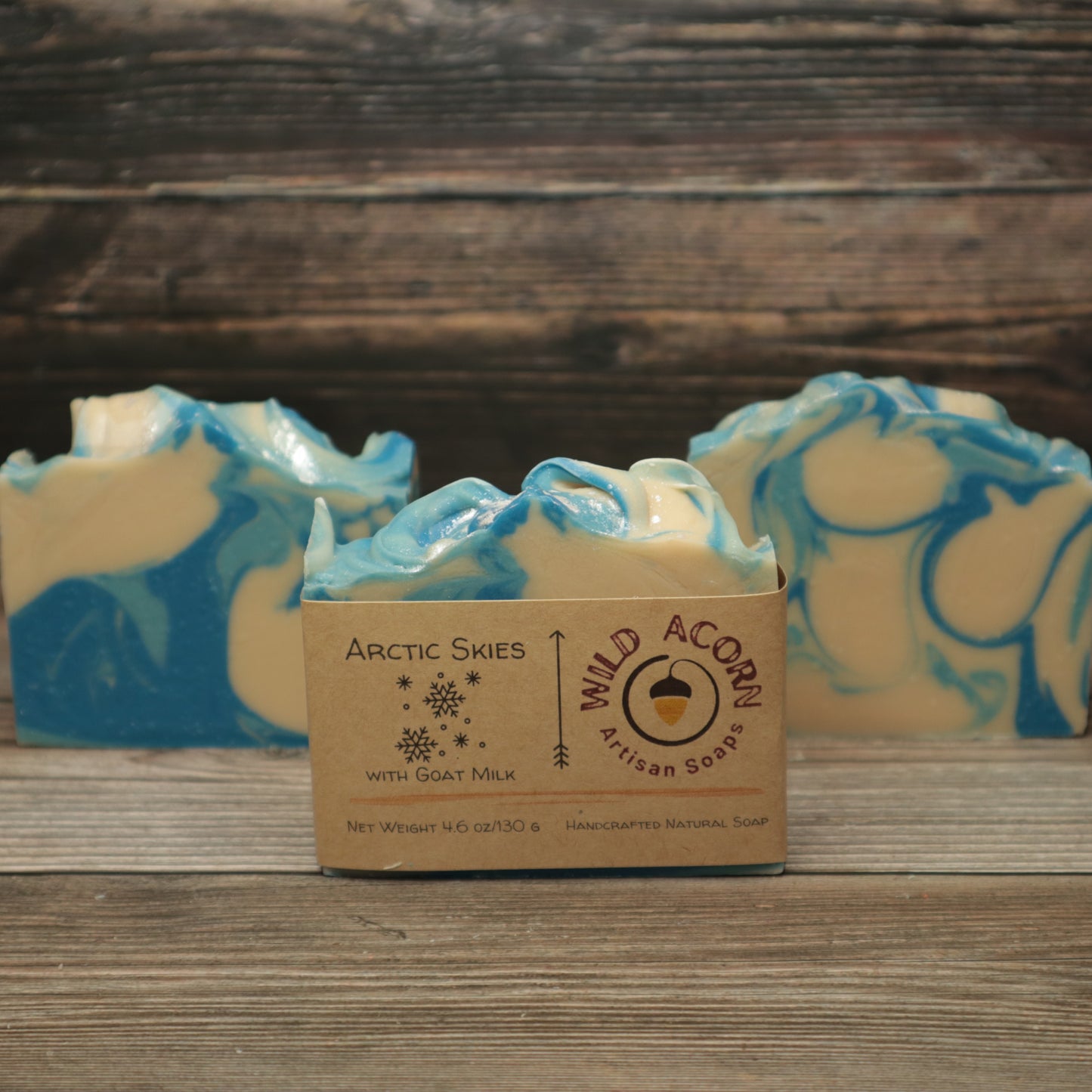 Three bars of soap with dark blue, light blue and white swirls. One bar has a tan label on it with a picture of snowflakes on it.