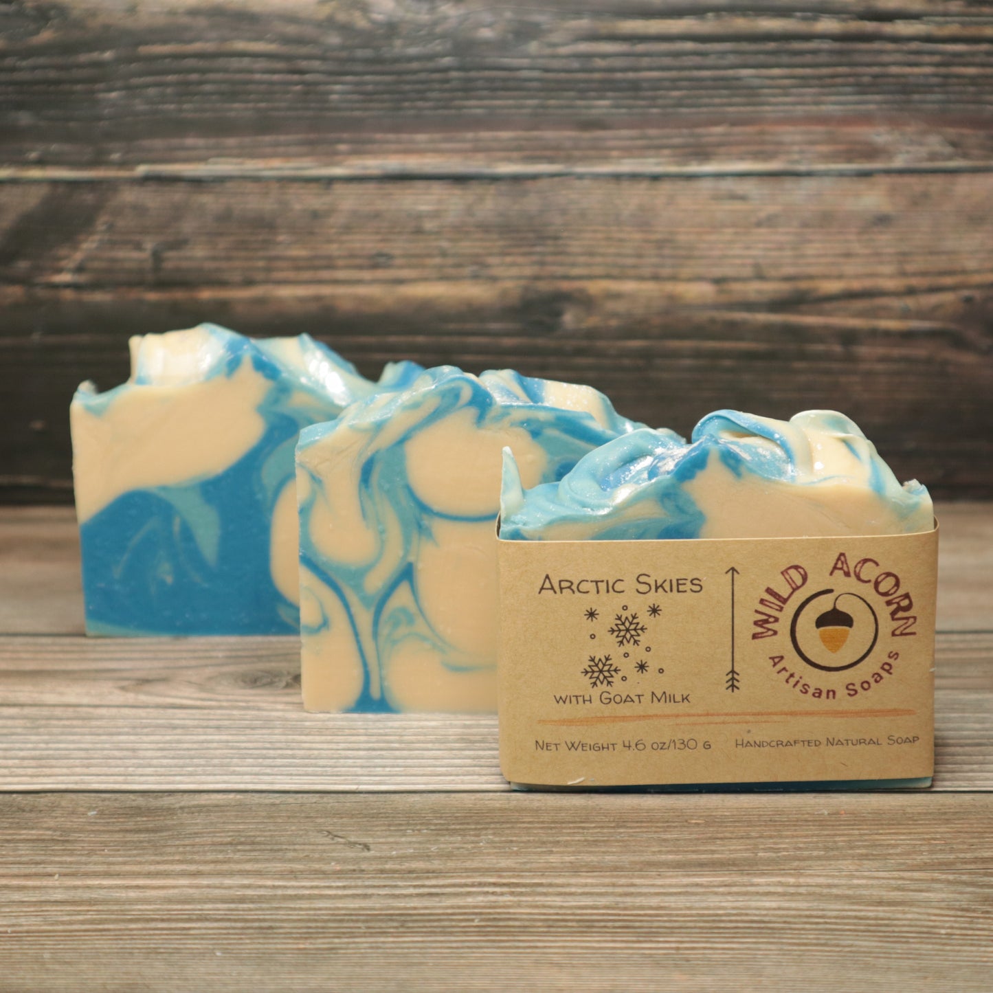 Three bars of soap with dark blue, light blue and white swirls. One bar has a tan label on it with a picture of snowflakes on it.
