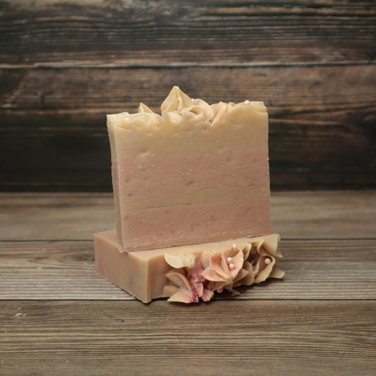 Two bars of soap with pink and white layers, frosting appearance on top with biodegradable glitter and pink pearl sugar sprinkles.
