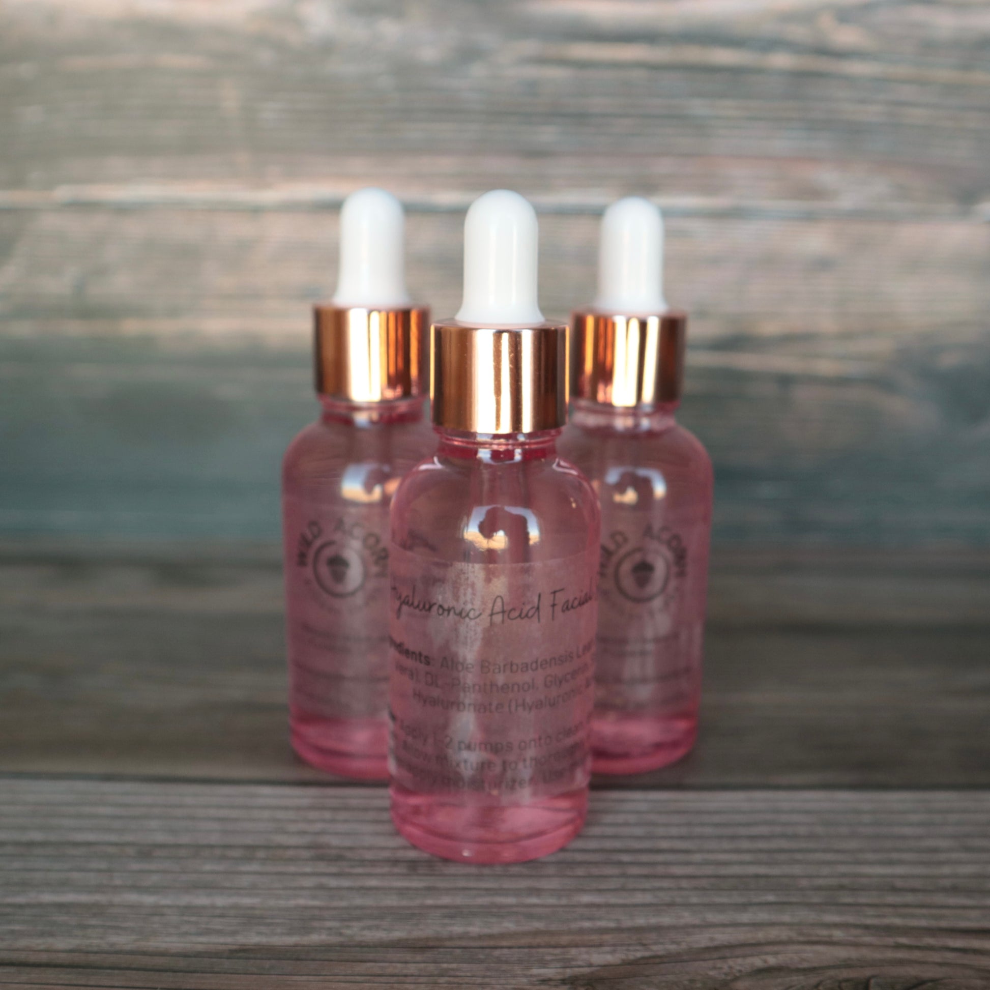 3 pink dropper bottles with white tips.